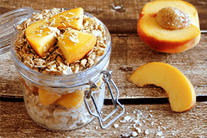 a jar of breakfast oats with fresh peaches