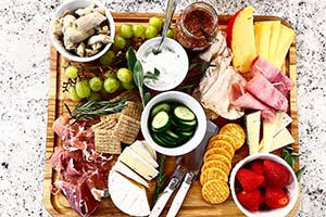 a fall snack board with crackers, cheeses, meats, fruits and veggies